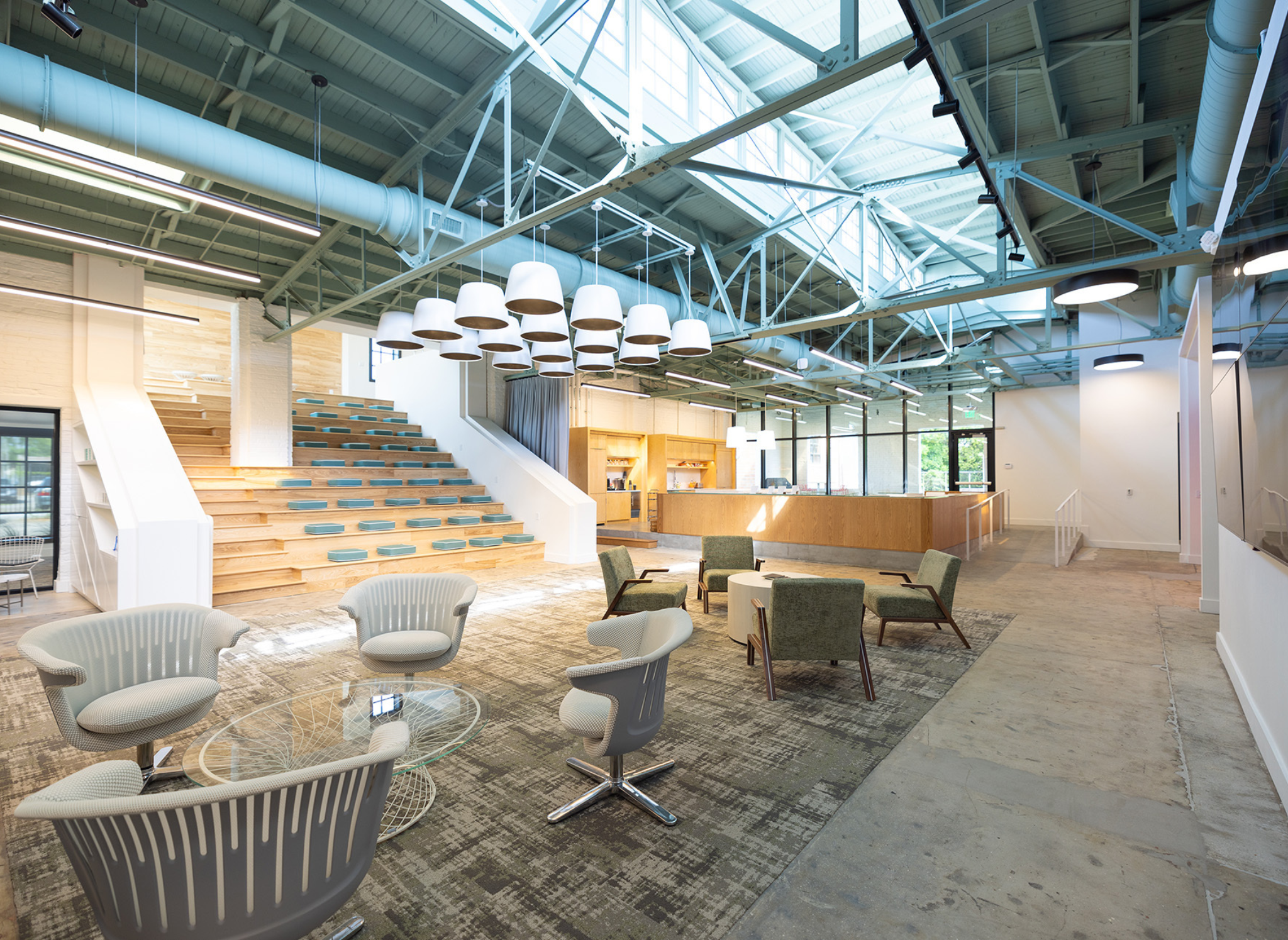 Open-concept meeting space with stadium seating and modern kitchen.
